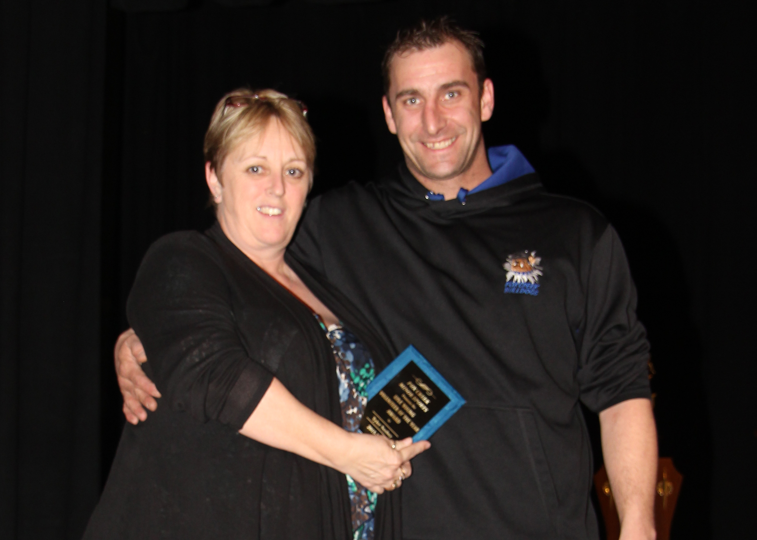 Brenda Burridge presents Tyler Scobey with the Lyle Young Volunteer of the Year Award